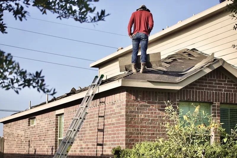 Professional roofer working on a residential roof in Century Village